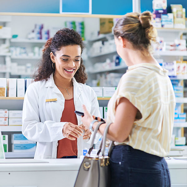Woman speaking to pharmacist in pharmacy
